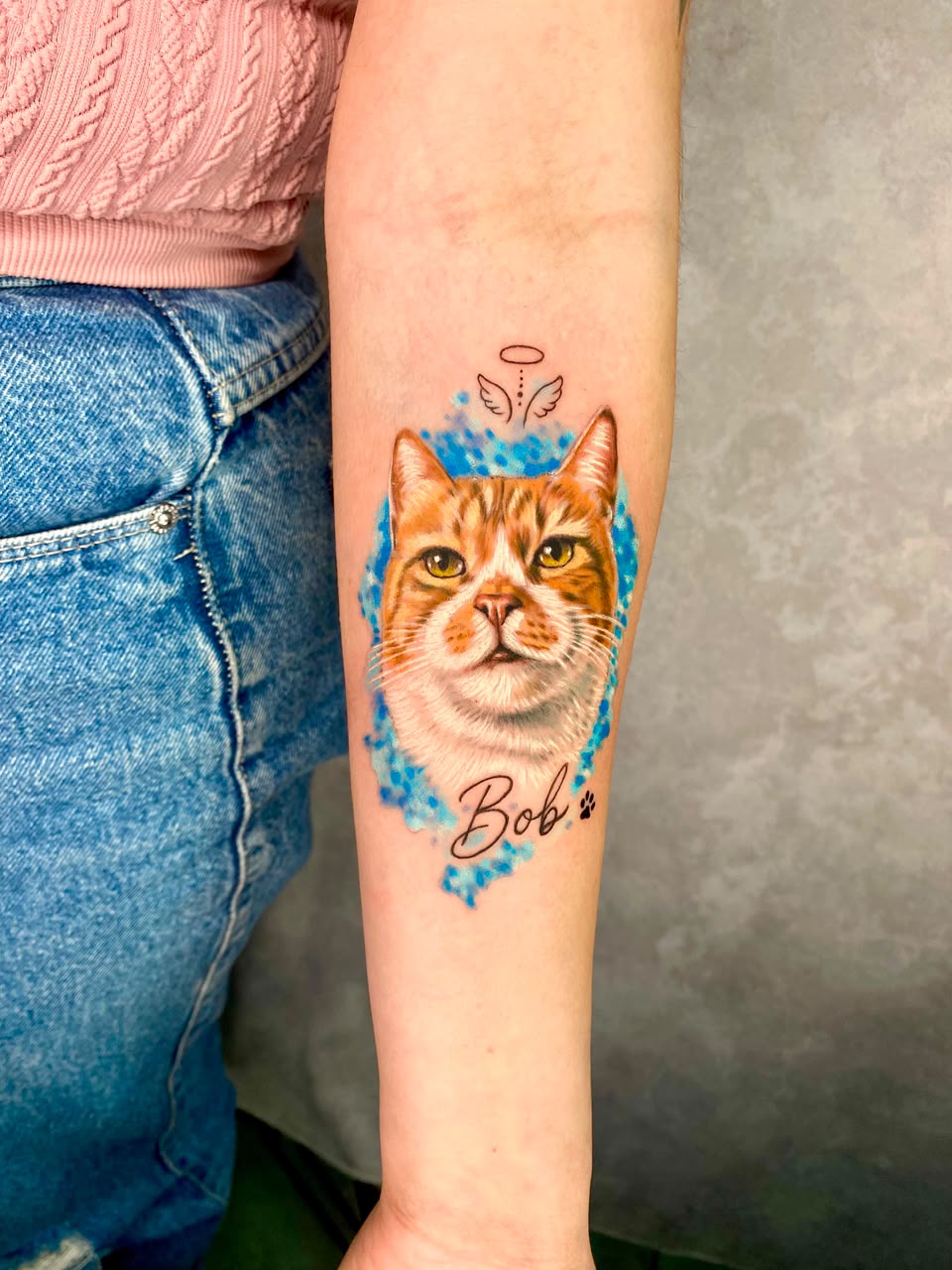 Tatuagem colorida delicada de gato com aquarela azul, feita por Felipe Santos em São Paulo