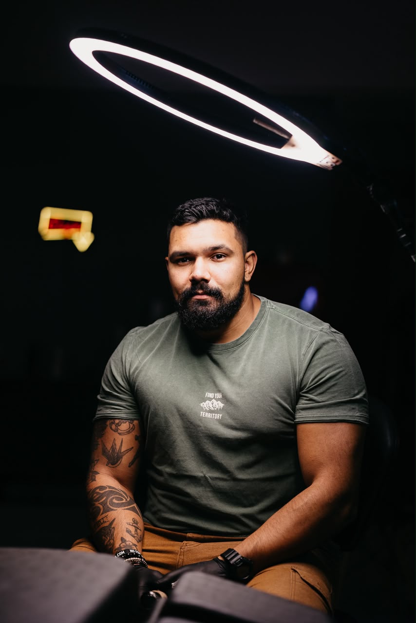 Felipe Santos, tatuador especialista em retratos realistas de pets, no estúdio